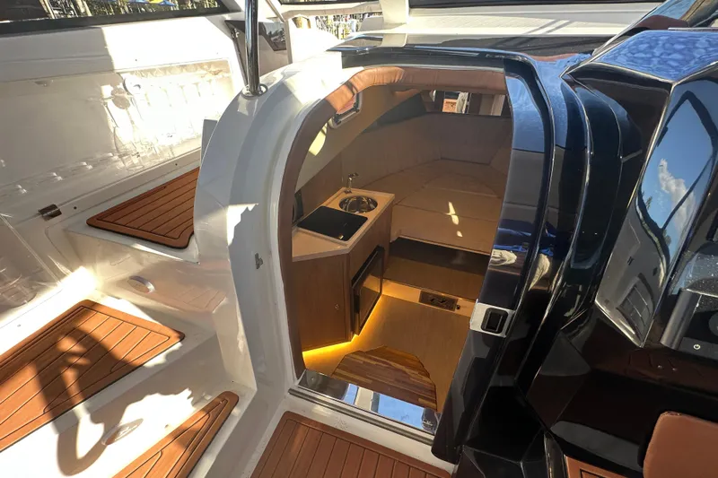  Yacht Photos Pics 2025 NX Boats 370 interior with wooden flooring and compact kitchenette.