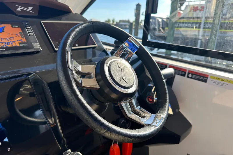  Yacht Photos Pics Steering wheel of 2025 NX Boats 370 with navigation display and controls.