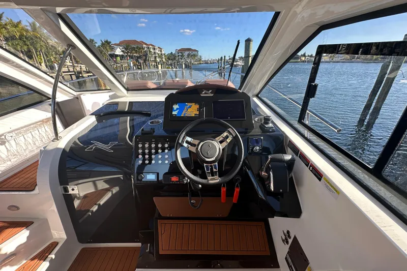  Yacht Photos Pics Interior view of 2025 NX Boats 370 helm with modern controls and waterfront scenery.