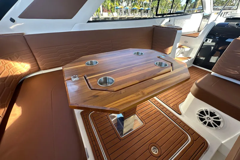  Yacht Photos Pics Luxurious interior of 2025 NX Boats 370 with wooden table and brown seating.