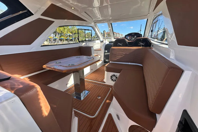  Yacht Photos Pics Interior of 2025 NX Boats 370, featuring brown seating and a wooden table.