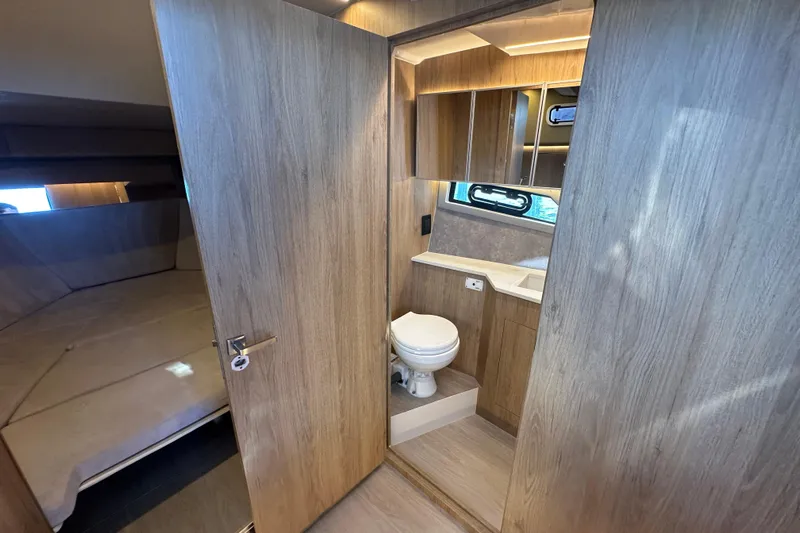  Yacht Photos Pics 2025 NX Boats 370 interior with wooden finish, featuring a compact bathroom and cozy sleeping area.