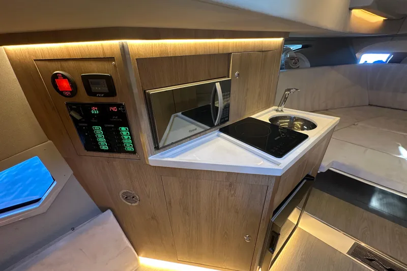  Yacht Photos Pics Modern kitchen area in 2025 NX Boats 370, featuring sleek appliances and wood finish.