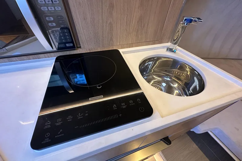  Yacht Photos Pics Modern kitchen area in 2025 NX Boats 370 with induction cooktop and sink.