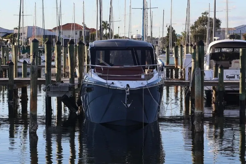  Yacht Photos Pics 2025 NX Boats 370 docked at a marina, surrounded by sailboats and calm water.