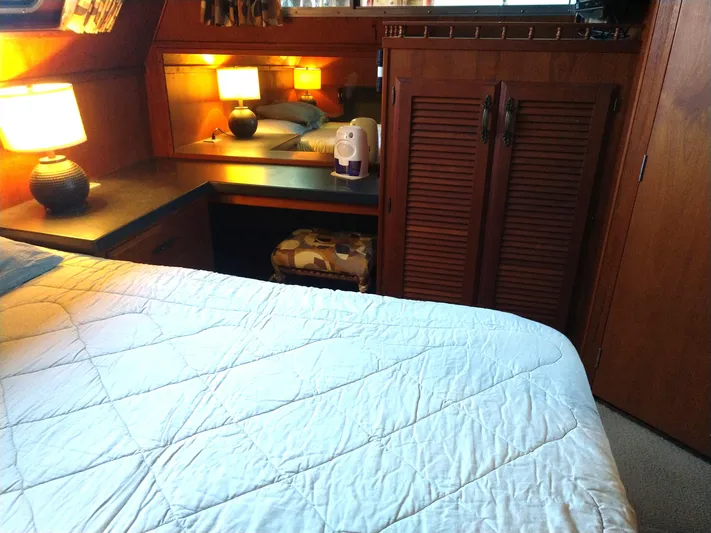 Elizabeth Rose Yacht Photos Pics Cozy bedroom interior of 1981 Tollycraft 43 Motoryacht with wooden cabinetry and soft lighting.