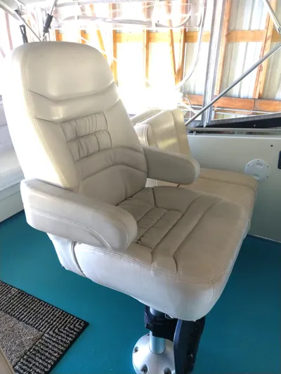Elizabeth Rose Yacht Photos Pics Captain's chair on 1981 Tollycraft 43 Motoryacht, featuring beige upholstery and adjustable armrests.