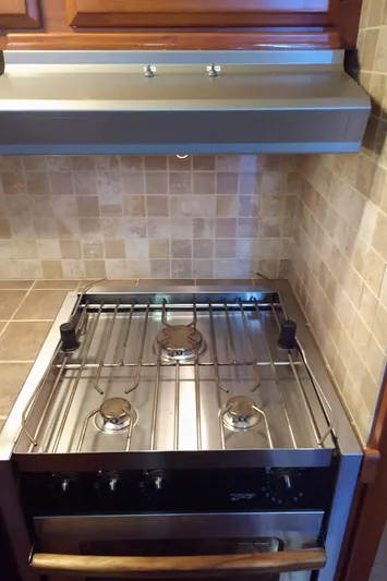 Elizabeth Rose Yacht Photos Pics Stove in 1981 Tollycraft 43 Motoryacht kitchen with tiled backsplash and wooden cabinetry.