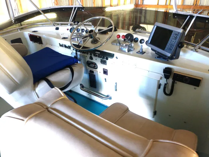 Elizabeth Rose Yacht Photos Pics 1981 Tollycraft 43 Motoryacht helm with steering wheel, navigation equipment, and cushioned seating.