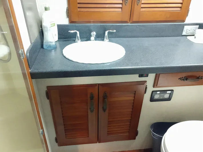 Elizabeth Rose Yacht Photos Pics 1981 Tollycraft 43 Motoryacht bathroom with sink, wooden cabinets, and countertop.