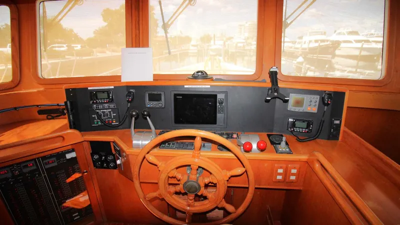 The Concession Yacht Photos Pics Pilothouse interior of 2001 Selene 53, featuring wooden steering wheel and navigation equipment.
