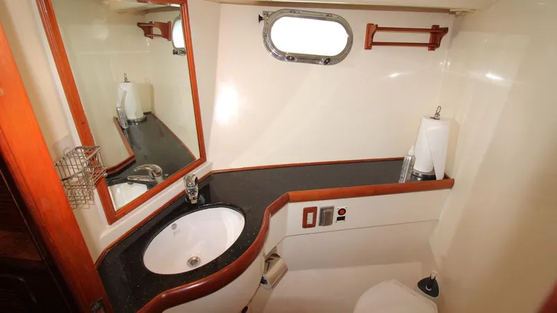 The Concession Yacht Photos Pics 2001 Selene 53 Pilothouse bathroom with sink, mirror, and porthole window.