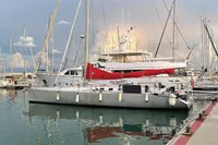 Finot Open 50 sailboat, 2005 model, docked in a marina with other yachts.