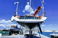Finot Open 50 sailboat from 2005 on a dock under a clear blue sky.