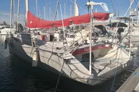 Sailboat Finot Open 50, 2005 model, docked with red sail and solar panels.