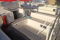 2005 Finot Open 50 sailboat cockpit with red sails and neatly arranged ropes.