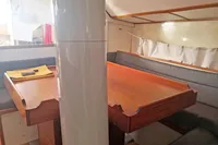 Interior of 2005 Finot Open 50 sailboat with wooden table and seating area.