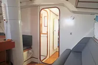 Interior of 2005 Finot Open 50 sailboat, featuring seating and doorway to cabin area.