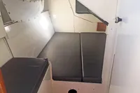 Interior cabin of 2005 Finot Open 50 sailboat with cushioned sleeping area.