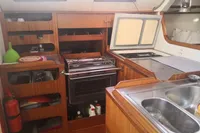 2005 Finot Open 50 yacht kitchen with wooden cabinetry and stainless steel sink.