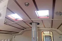 Interior of 2005 Finot Open 50 sailboat with skylights and wooden ceiling beams.