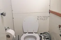 2005 Finot Open 50 yacht bathroom with manual marine toilet.