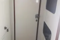 Interior view of a 2005 Finot Open 50 sailboat, featuring a white cabin door.