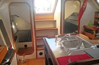 Interior of 2005 Finot Open 50 yacht with kitchen sink and cozy seating area.