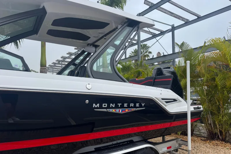  Yacht Photos Pics 2025 Monterey Elite 27 OB boat, sleek design, black and white exterior, parked outdoors.