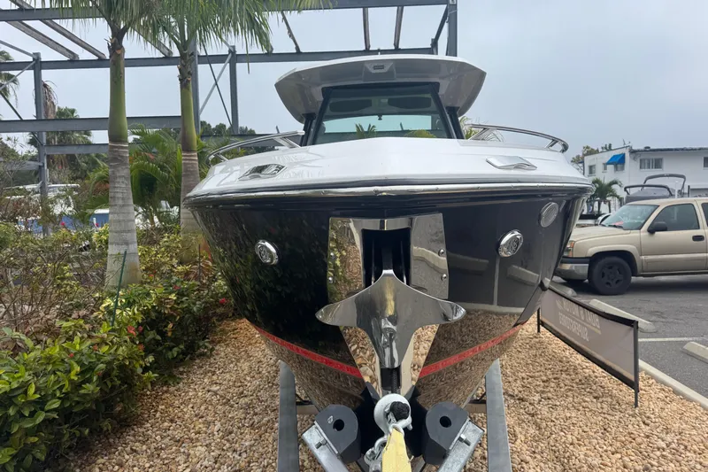  Yacht Photos Pics 2025 Monterey Elite 27 OB boat on display, front view with anchor, surrounded by palm trees.