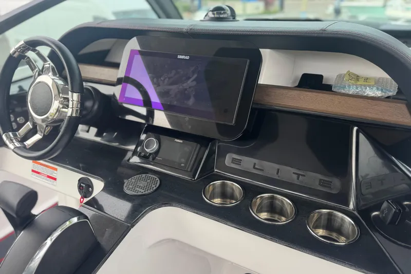  Yacht Photos Pics 2025 Monterey Elite 27 OB dashboard with steering wheel, touchscreen, and cup holders.