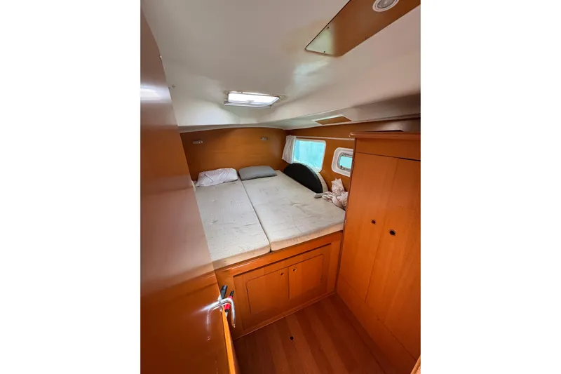 Betty Mae Yacht Photos Pics Cozy cabin interior of 2006 Lagoon 380 catamaran with bed and wooden storage.
