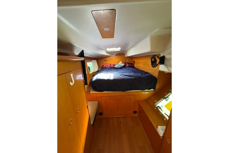 Betty Mae Yacht Photos Pics Cozy cabin interior of 2006 Lagoon 380 catamaran with bed and wooden furnishings.