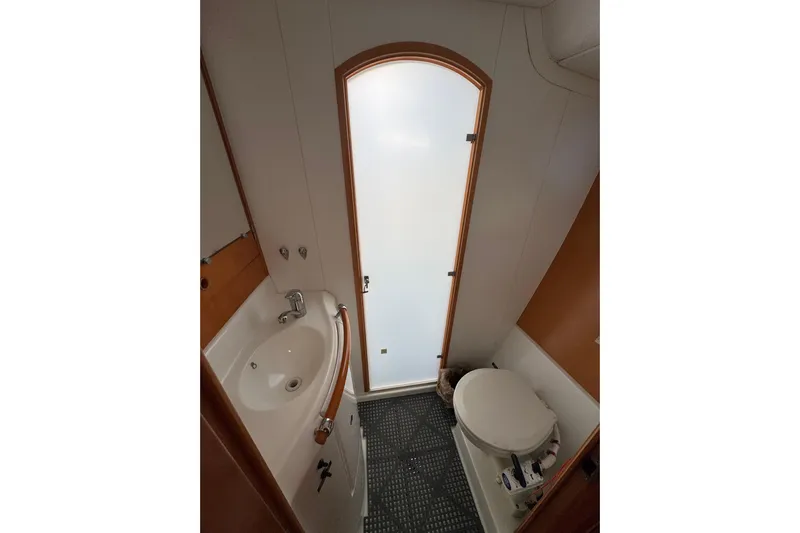 Betty Mae Yacht Photos Pics Bathroom interior of 2006 Lagoon 380 catamaran with sink, toilet, and frosted door.
