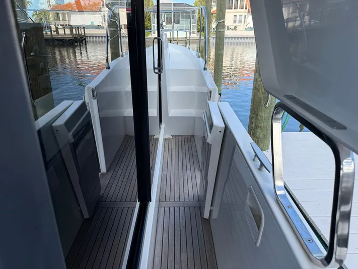 Seven Grand Yacht Photos Pics 2016 Beneteau Swift Trawler 30, side deck view with wooden flooring and marina background.