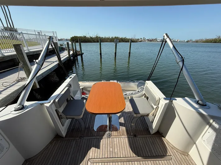 Seven Grand Yacht Photos Pics 2016 Beneteau Swift Trawler 30 aft deck with seating and table, overlooking calm waters.