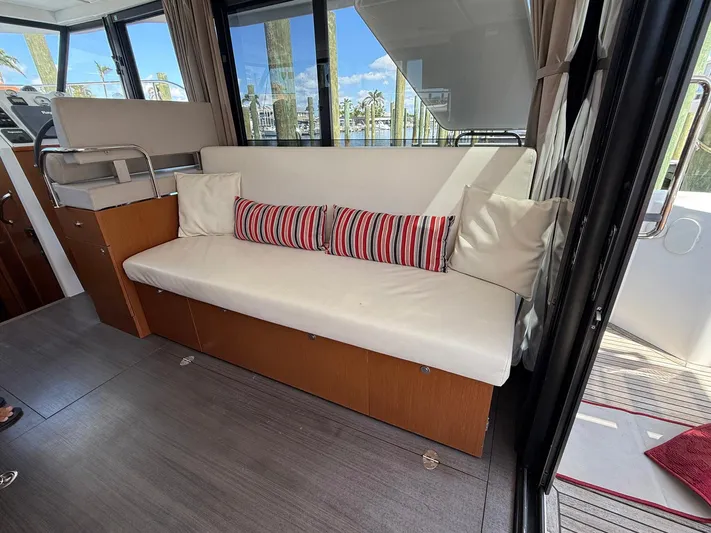 Seven Grand Yacht Photos Pics Interior of 2016 Beneteau Swift Trawler 30 with white sofa and striped cushions.