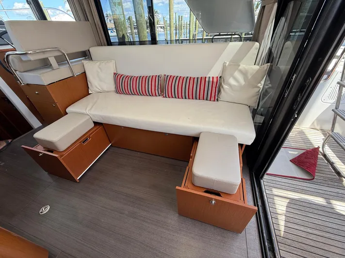 Seven Grand Yacht Photos Pics Cozy seating area on 2016 Beneteau Swift Trawler 30 with striped cushions and storage.