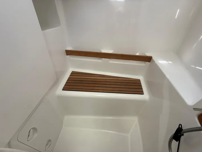 Seven Grand Yacht Photos Pics Interior of 2016 Beneteau Swift Trawler 30, featuring a wooden bench in a white shower area.