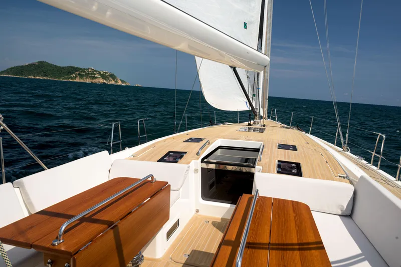 Invictus Yacht Photos Pics 2023 Nautor Swan 55 yacht sailing on open sea with island in background.