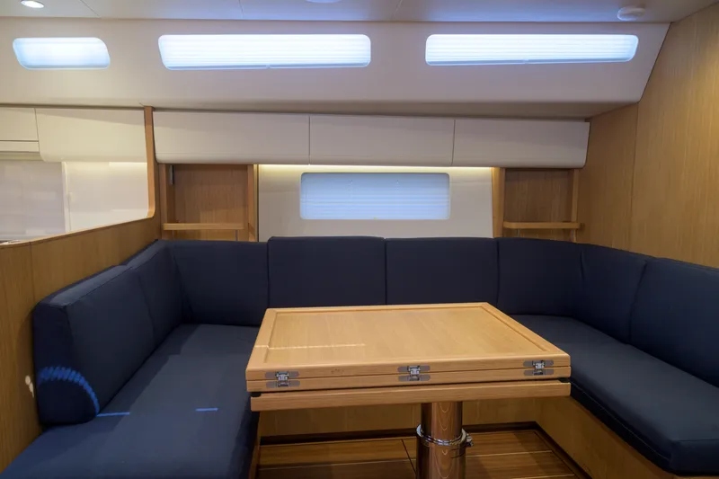 Invictus Yacht Photos Pics Interior of 2023 Nautor Swan 55 yacht with elegant seating and wooden table.