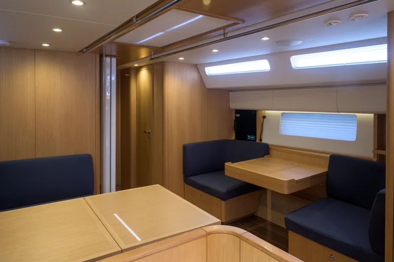 Invictus Yacht Photos Pics Luxurious interior of 2023 Nautor Swan 55 yacht with modern seating and wooden finishes.