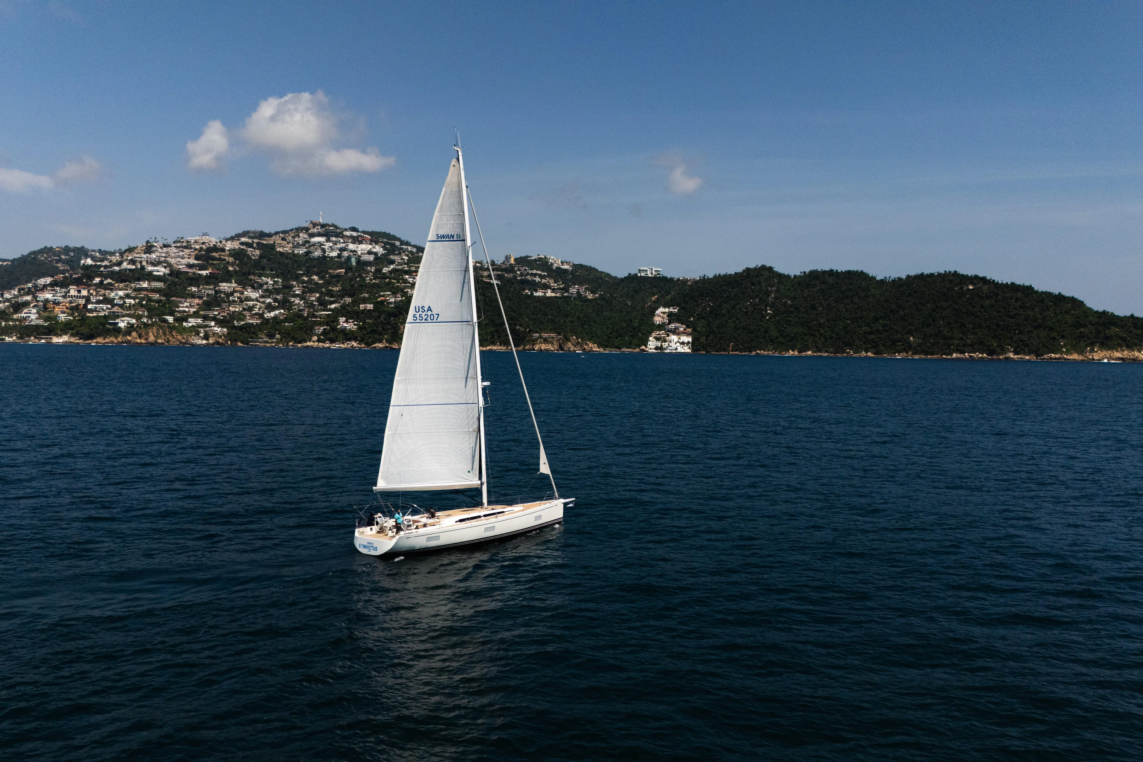 Invictus Yacht Photos Pics Swan 55 sailing near scenic coastline, 2023 Nautor Swan model.