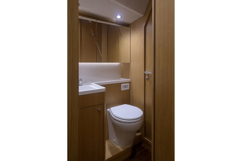Invictus Yacht Photos Pics Modern bathroom interior of 2023 Nautor Swan 55 yacht, featuring sleek wood finishes.