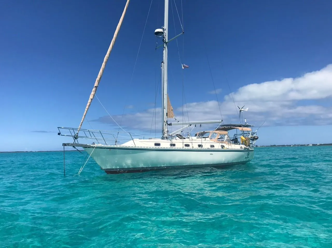 Sailboat Caliber 40LRC 2003 anchored in clear turquoise waters under a bright blue sky.