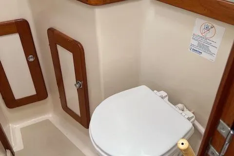 Agandau Yacht Photos Pics 2003 Caliber 40LRC boat bathroom with wooden accents and a white toilet.