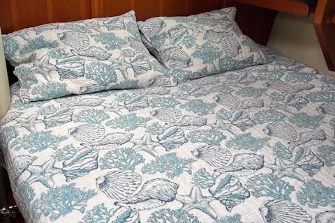 Agandau Yacht Photos Pics Nautical-themed bedding in a 2003 Caliber 40LRC cabin, featuring seashell and coral patterns.