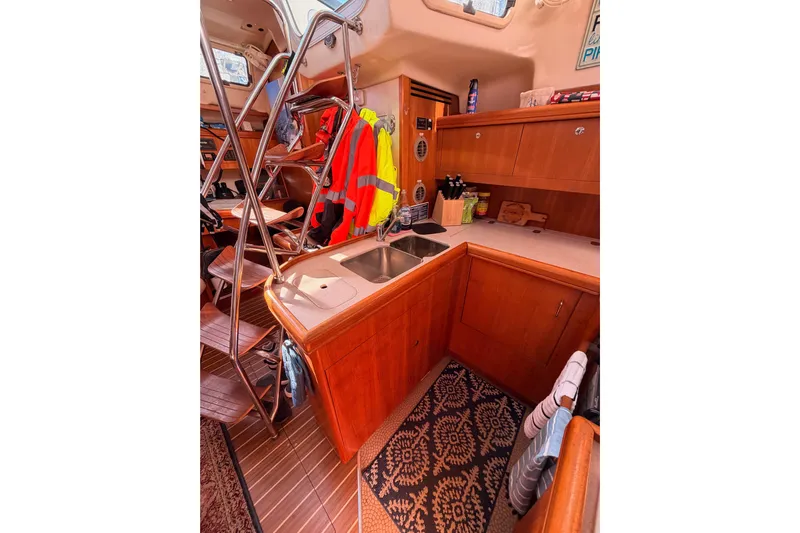 Thursday's Child Yacht Photos Pics Interior of 2005 Hunter Passage 456 yacht, featuring a compact kitchen with wooden cabinetry.