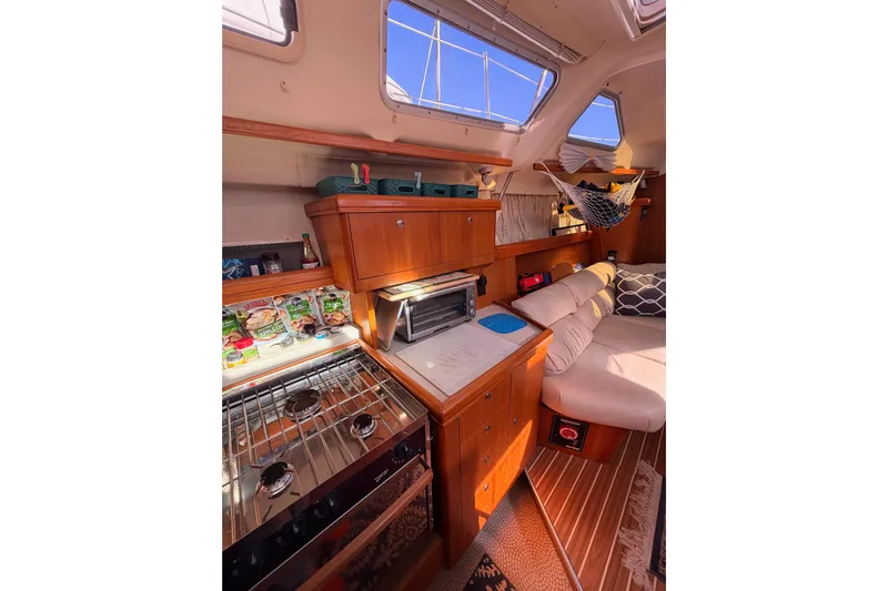 Thursday's Child Yacht Photos Pics Interior of 2005 Hunter Passage 456 yacht with cozy seating and kitchen area.