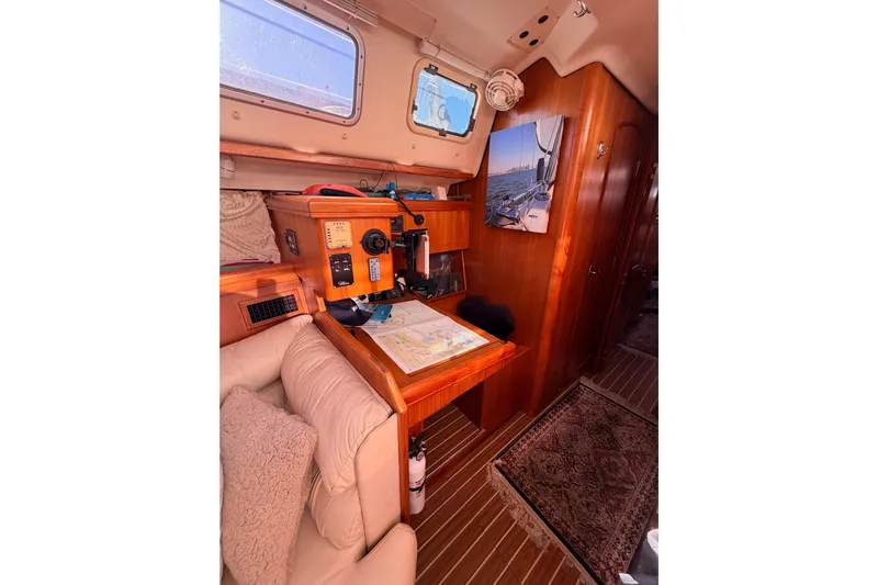Thursday's Child Yacht Photos Pics Interior of 2005 Hunter Passage 456 yacht with navigation station and cozy seating.